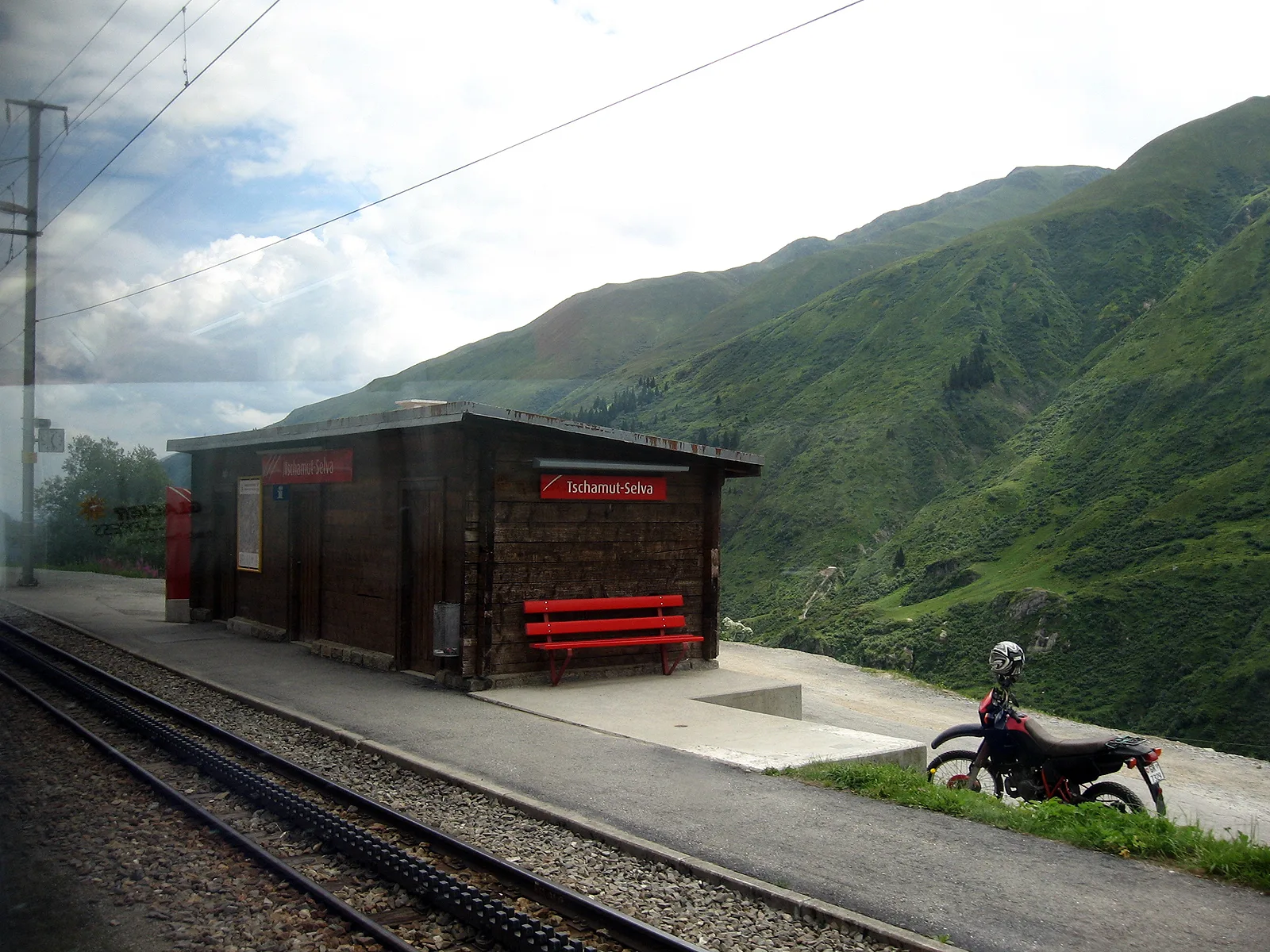 A small Swiss mountain station seen from a passing train window