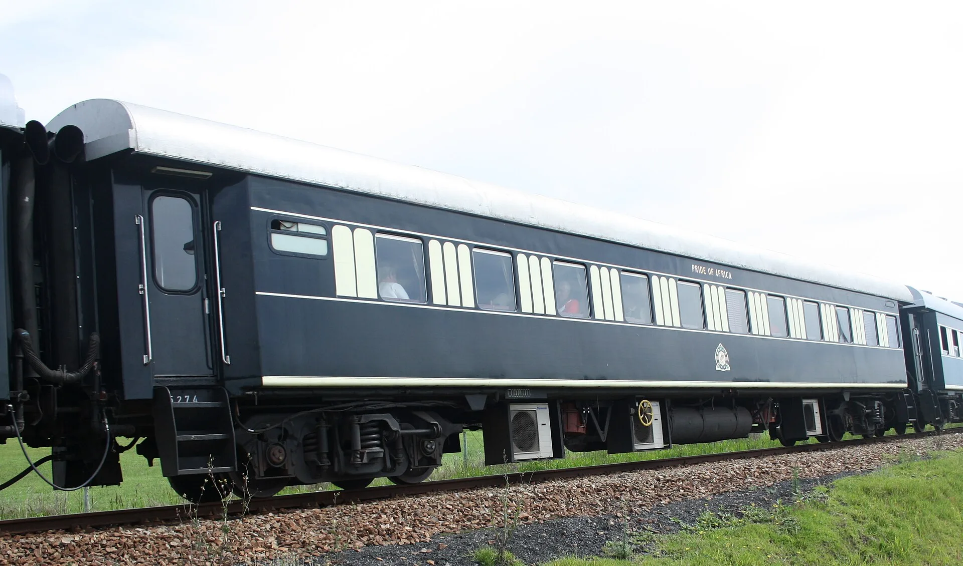 A dark green Rovos Rail passenger carriage standing on the track