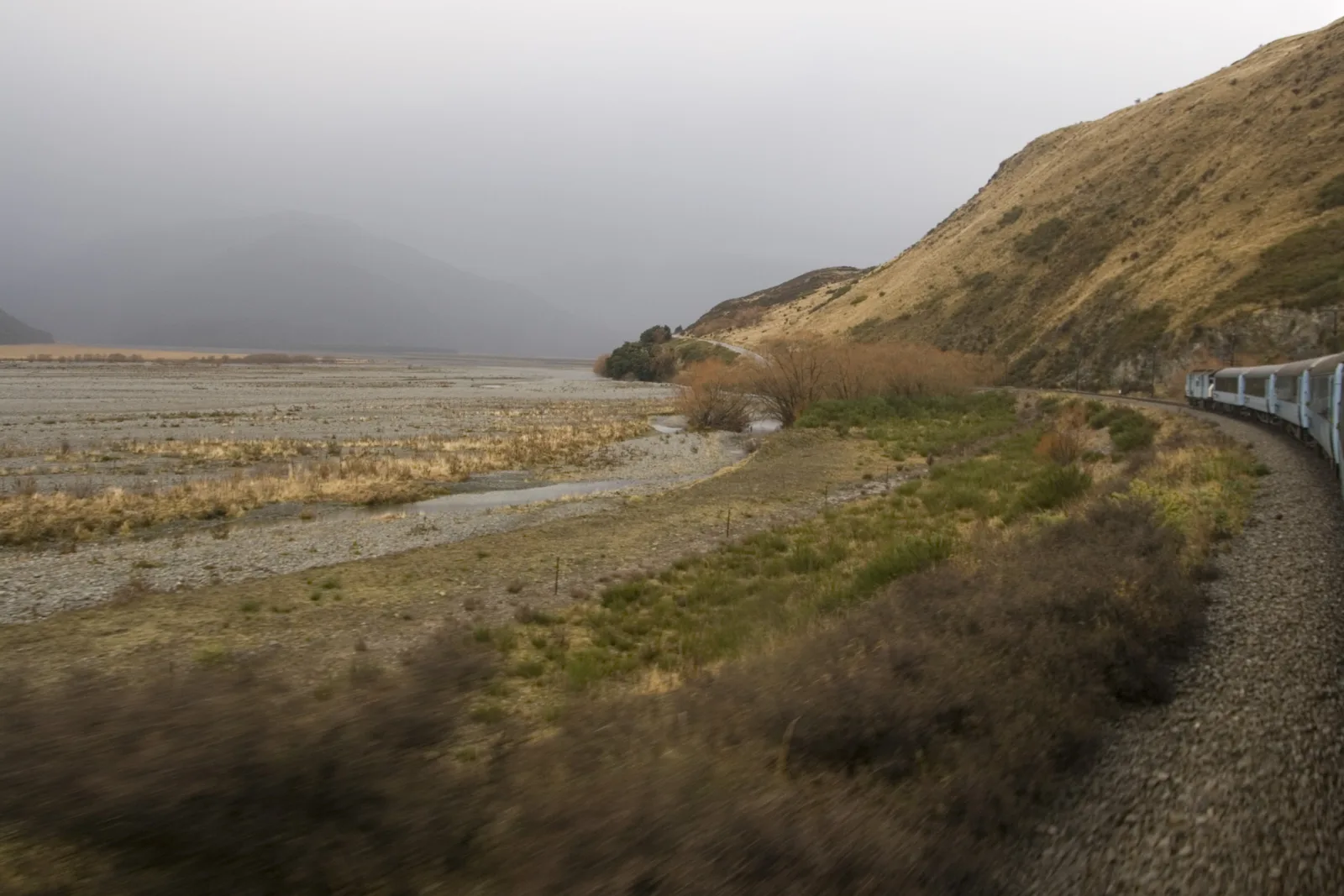 A passenger train travelling through New Zealand mountain country